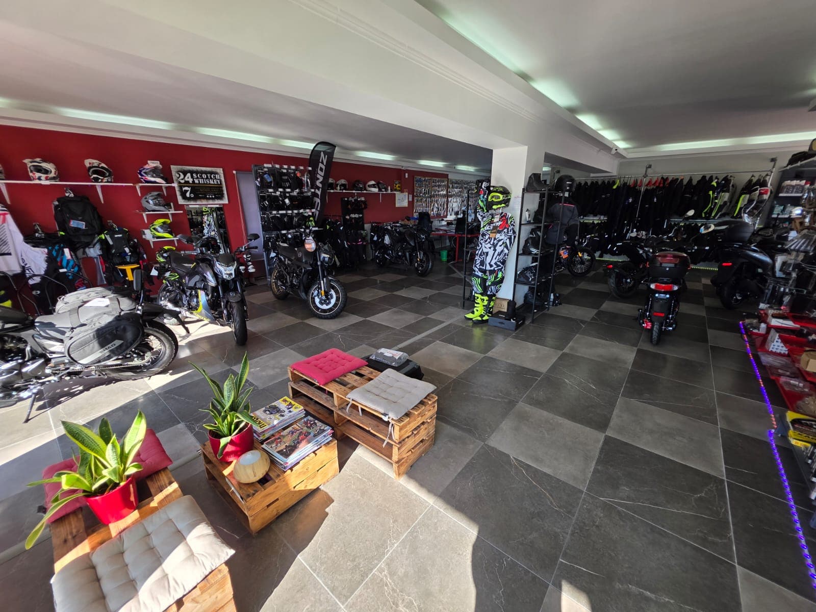 Interior da loja JD Motocar com motas e equipamento