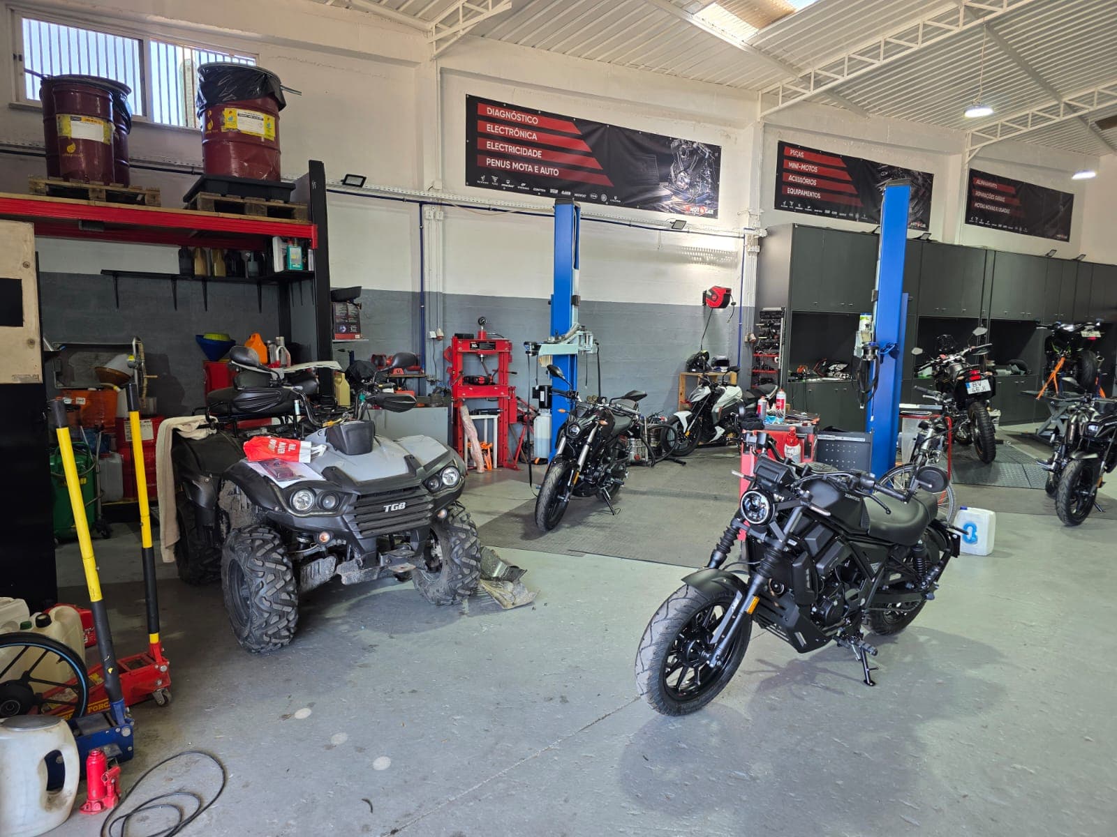 Oficina da JD Motocar com elevadores e motas em assistência